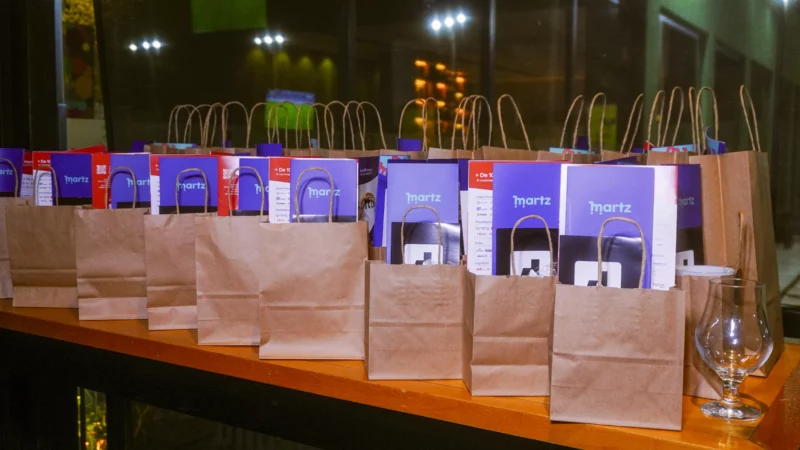 Sacolas de papel com brindes e materiais promocionais do evento Martz