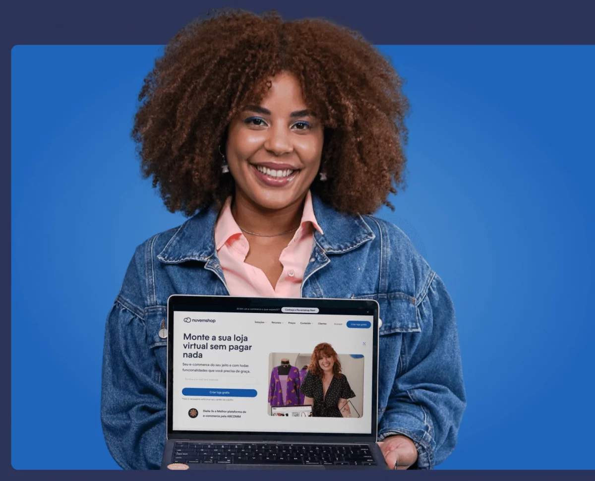 imagem de mulher negra segurando um computador com tela aberta e mostrando a plataforma de e-commerce da nuvemshop